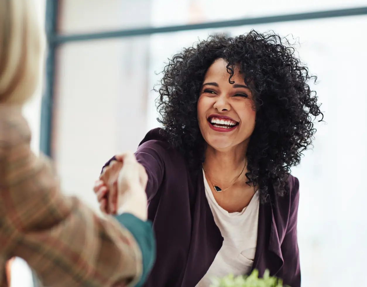 A woman shaking hands with another person.