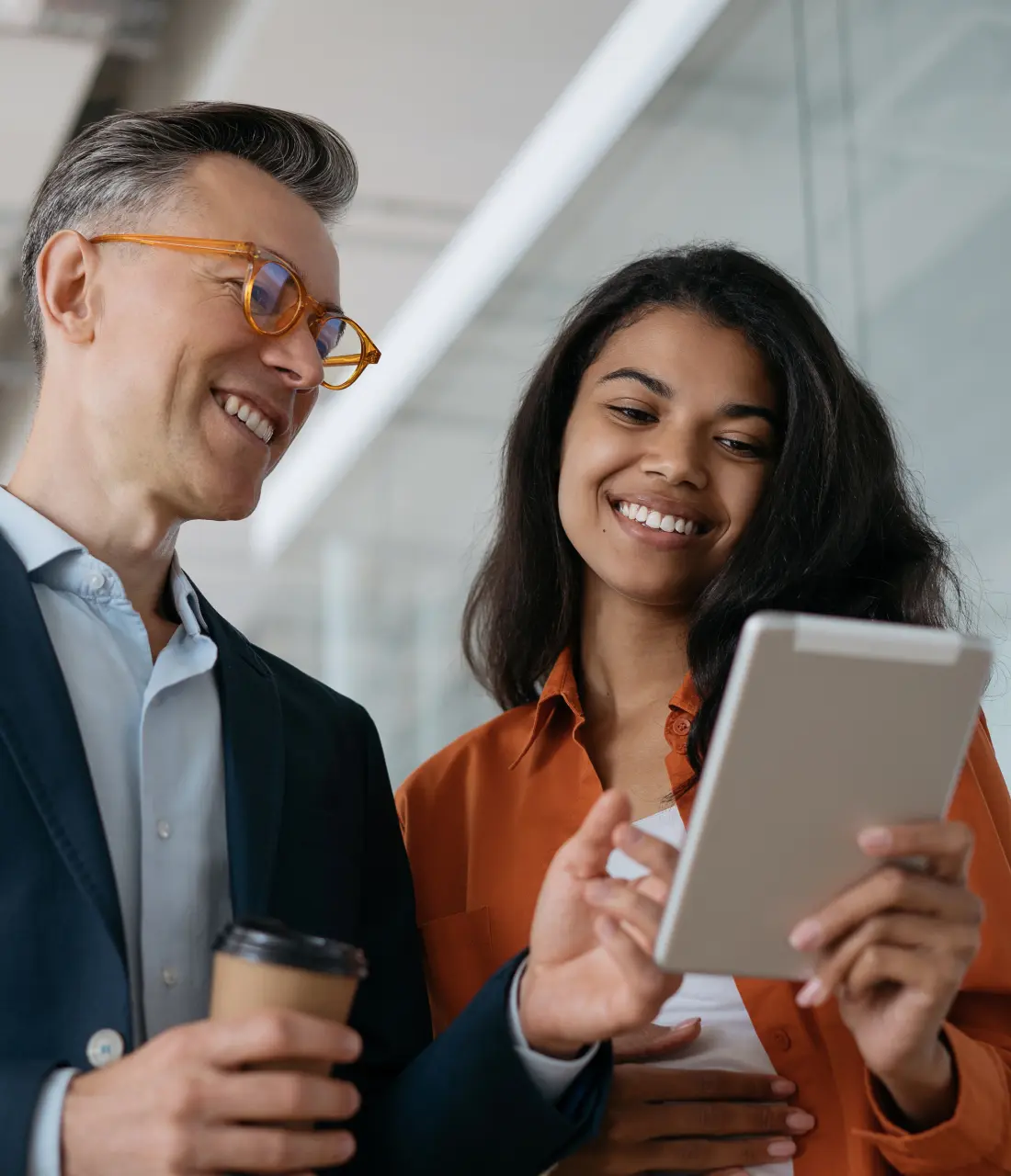 Two people looking at a tablet in an office.