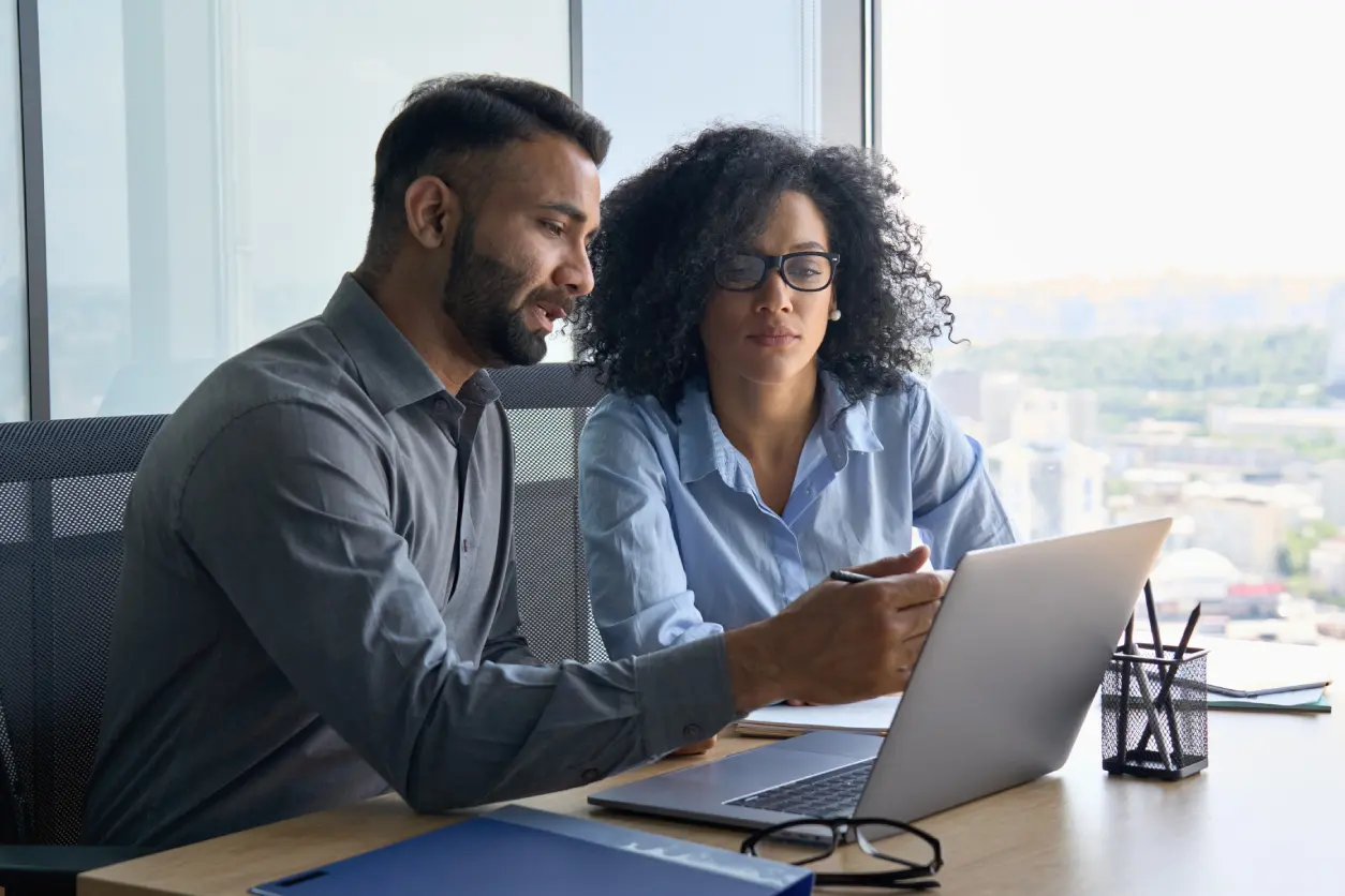 A man and woman looking at a laptop